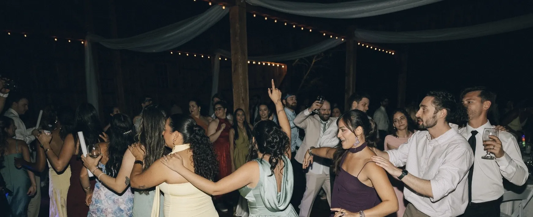 Guest pointing up while dancing at a wedding reception