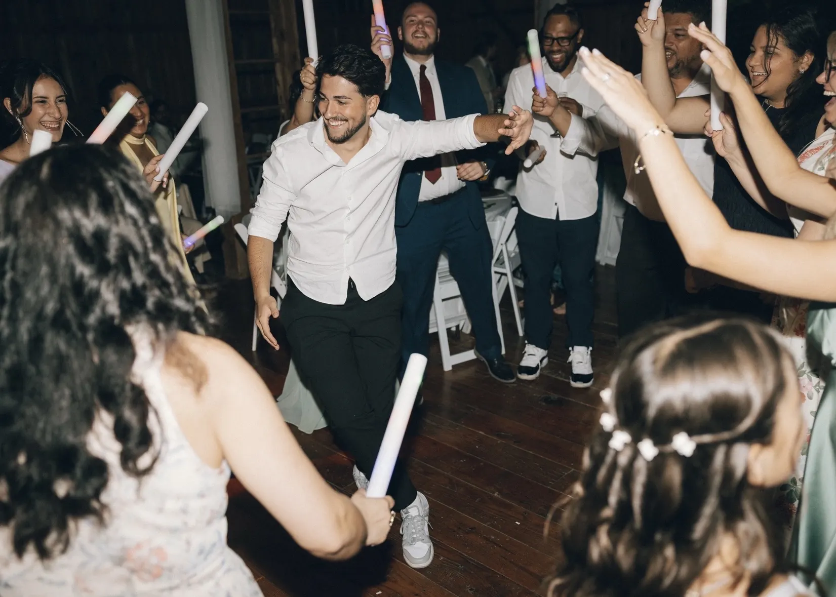 Guests dancing with light sticks at a wedding reception